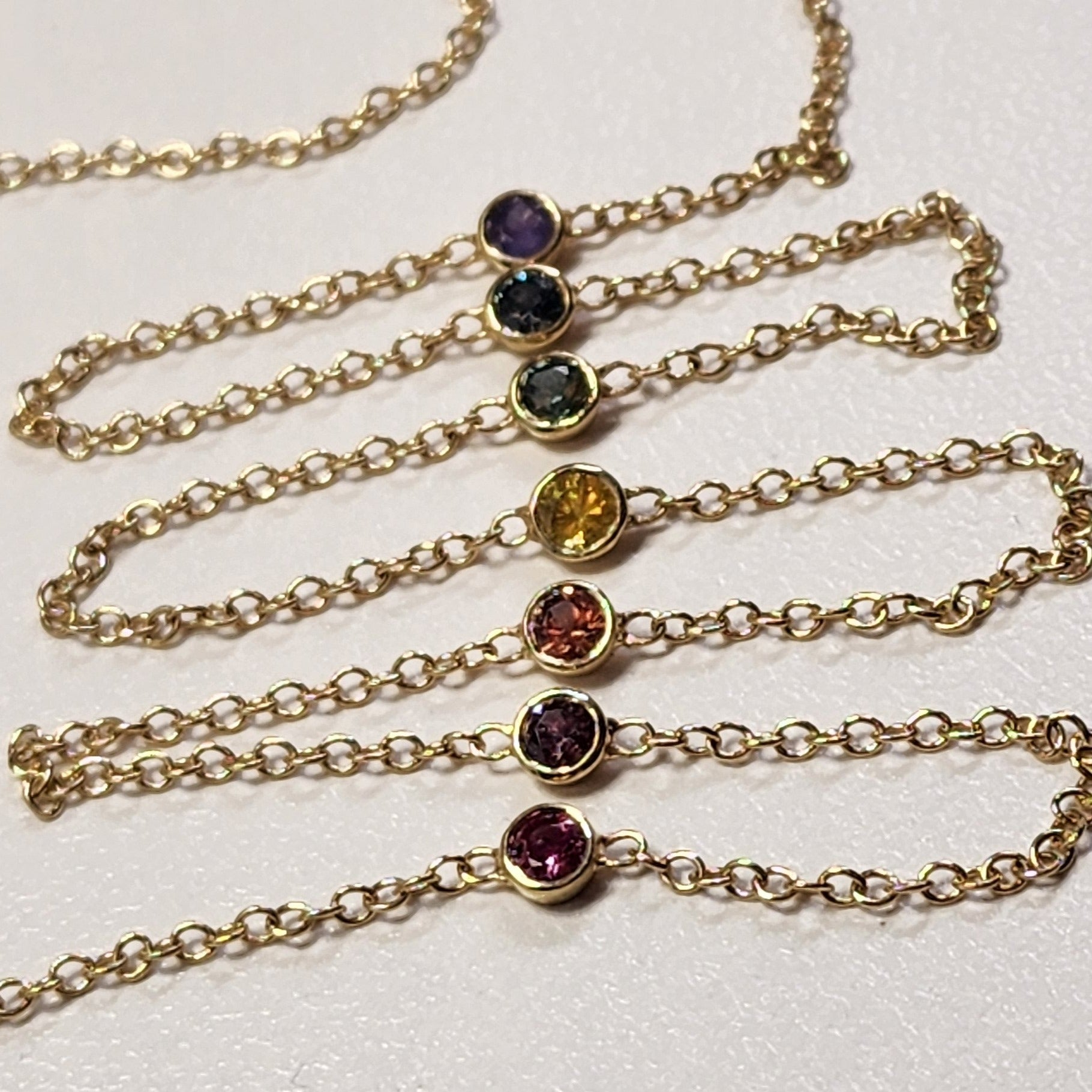 Necklace - Montana Sapphire .88 CTW 7 Rainbow Colored Rounds Bezel Mounted in 14K Yellow Gold